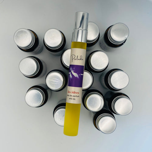 Collection of small bottles with a central tube labeled 'Prelude' on a light gray background