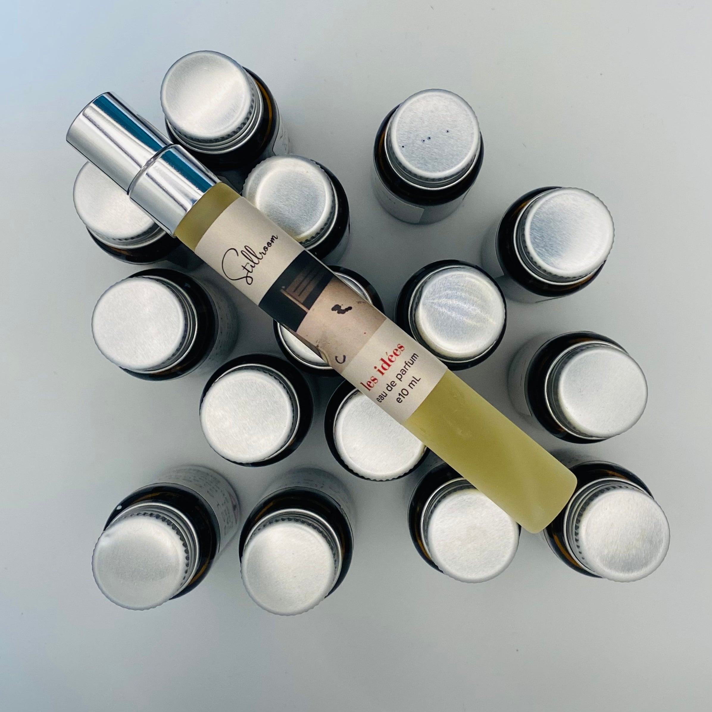 Collection of small bottles with one prominently displayed bottle labeled 'Stillroom'.